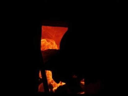 stoking firewood into the anagama