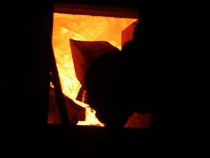 stoking firewood into the anagama
